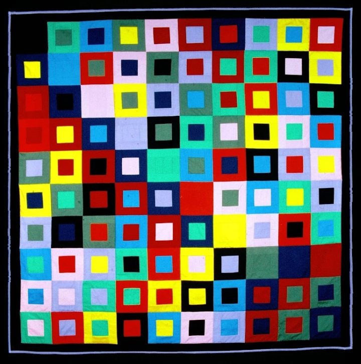 City Limits, un quilt de carrés emboîtés en dix couleurs sur fond noir, avec un mince cadre lavande